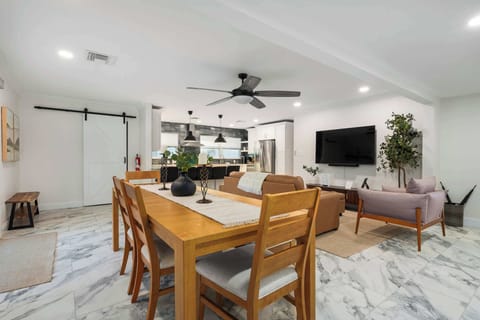 Gather in this bright, open dining and living area with modern furnishings, spacious seating, and seamless flow to the kitchen. Ideal for shared meals, game nights, and relaxing together in comfort and style.