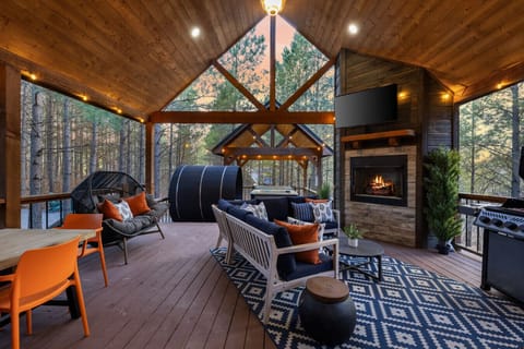 Start your stay on the covered deck—string lights, lounge seating, and an outdoor fireplace that turns pine‑forest evenings into your group’s favorite hangout. Pour a drink, cue the convo, stay awhile.