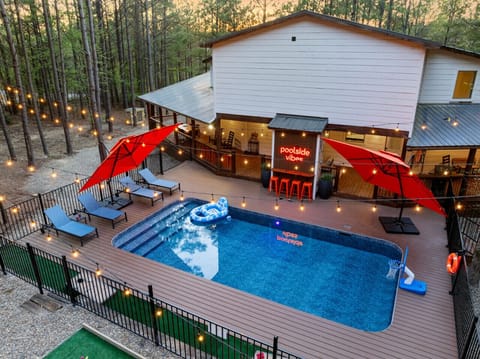 Brand-new private pool deck with custom mini-putt, premium loungers, red umbrellas & outdoor bartop — the ultimate Broken Bow luxury cabin experience for groups up to 14.