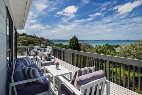 sunny balcony leading off upstairs living and bedrooms. Lounge seating and outdoor dining with large outdoor umbrella for shade.