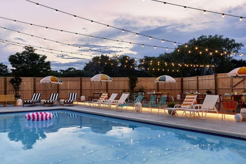 Evening pool scene with string lights and lounge seating