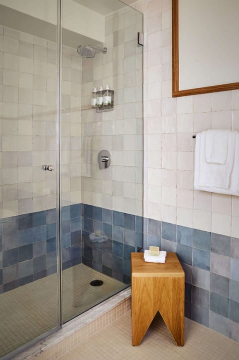 Walk-in shower with glass door and tiled walls