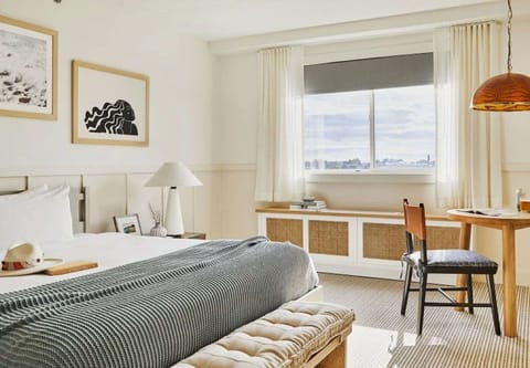 King bed room with soft bedding, desk, and natural light