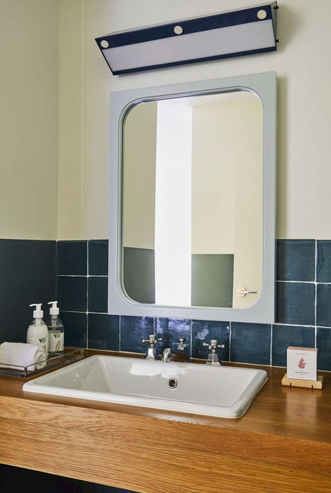 Bathroom sink with mirror, soap, and fresh towels