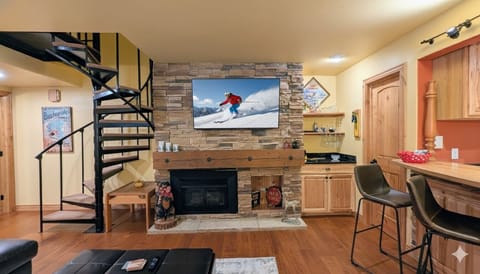 Cozy up in your mountain-inspired living space with a stone fireplace, full kitchen, and spiral stairs leading to your private loft retreat.