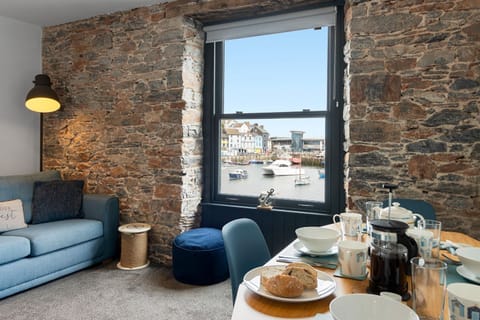 The living area complete with sofas and dining table is the perfect place to socialise whilst taking in the spectacular sea views