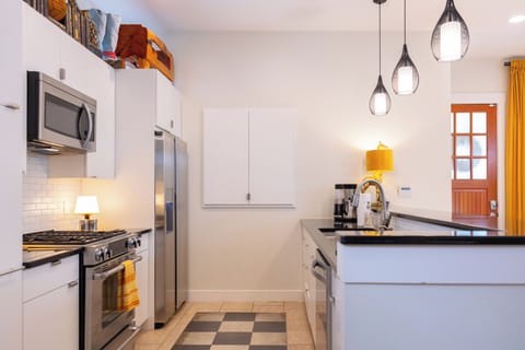 Your modern kitchen invites culinary adventures with sleek appliances, granite counters, and cheerful pendant lighting creating the perfect space for meals.