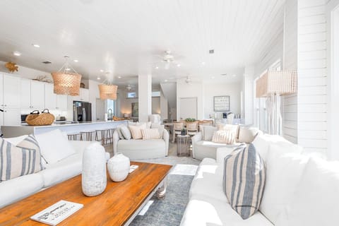 Sink into plush white sofas in your bright, airy living space where coastal vibes meet modern comfort.