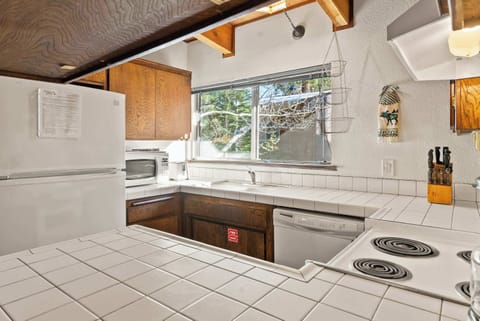 Fully equipped kitchen with tiled counters, white appliances, and a morning coffee station.