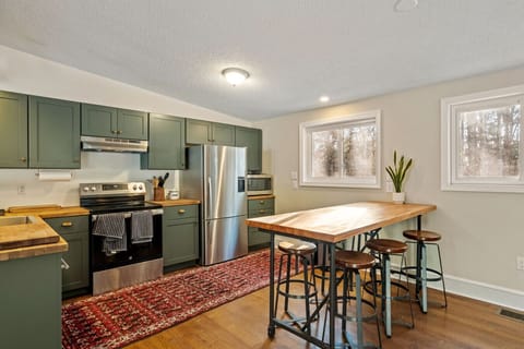 Fully equipped kitchen featuring bar seating and woodland views