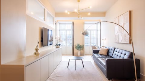 Bright and airy lounge with high ceilings, contemporary lighting, and French balconies overlooking the charming Santa Catarina street. #PortoStay #DesignApartment #NaturalLight