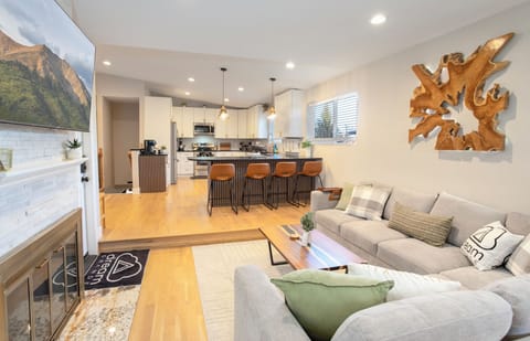 Modern living room with large sectional, smart TV, and contemporary art