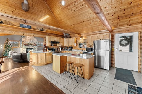 Spacious log kitchen with granite counters, stainless appliances, island seating