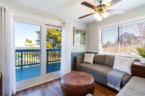 Bright living room w/ comfy sofa, TV & large windows letting in abundant natural light