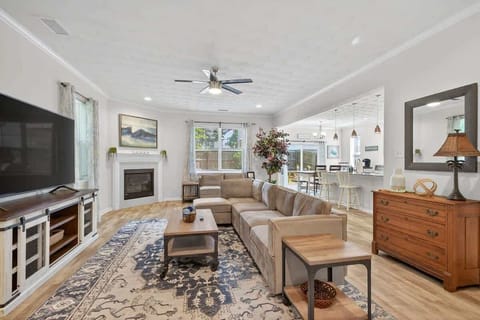 Bright and spacious living room featuring a large flat-screen TV, comfortable sectional seating, and plenty of natural light, perfect for relaxing with family or friends.