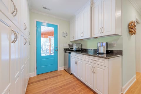 Bright and functional prep kitchen with ample storage, coffee station, and easy access to the outdoors.