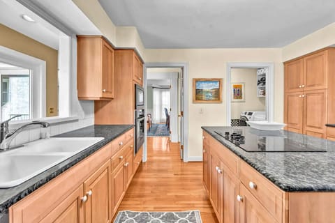 Spacious galley kitchen with granite counters and warm wood cabinets makes your meal prep a pleasure.