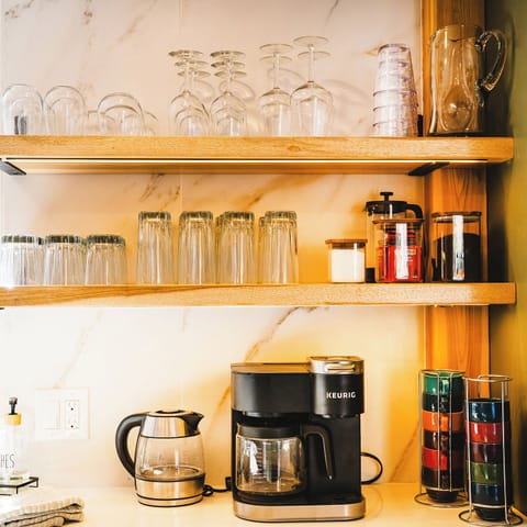 Your well-stocked coffee station awaits with premium equipment and elegant glassware, making every morning brew a delightful ritual in your home away from home.
