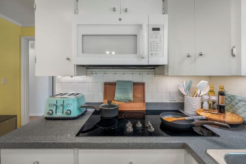 Clean and well-lit kitchen featuring a double sink and charming garden window