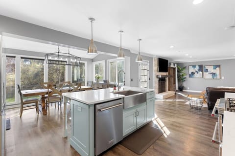 Bright, open-concept kitchen and dining area featuring a large island with seating, modern appliances, and all the supplies you need to cook a meal for the family.