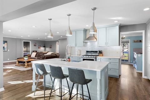 Bright, open-concept kitchen and dining area featuring a large island with seating for 3, modern appliances, and all the supplies you need to cook a meal for the family.