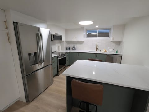 Full kitchen with induction range, oven, large refrigerator with filtered water