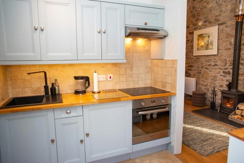 Light blue kitchen units with sink, hob, oven and extractor hood