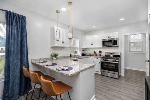 Modern kitchen with gas stove, bar seating, and natural light