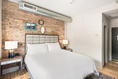 Drift off beneath soft lamps and a tailored plaid headboard.