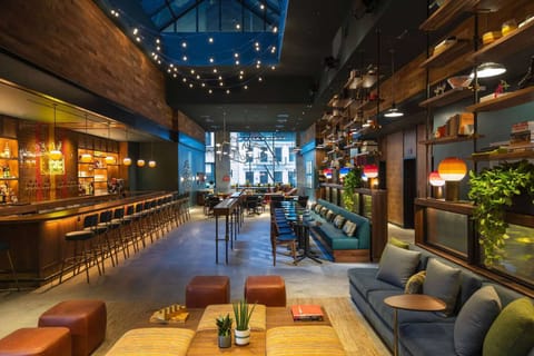 Wide view of lounge space with string lights and seating zones