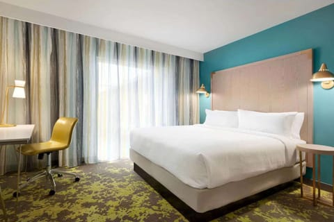 King bed with work desk and soft window light