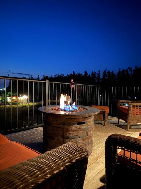 Deck seating in the evening. Nestled in the woods, ocean view, continue-flow fire pit - peaceful!