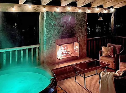 Covered porch with hot tub, fireplace and sitting area.  Also has a grill.