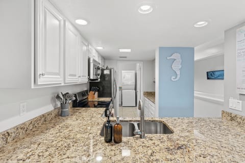 Close-up of the kitchen sink and granite breakfast bar area.