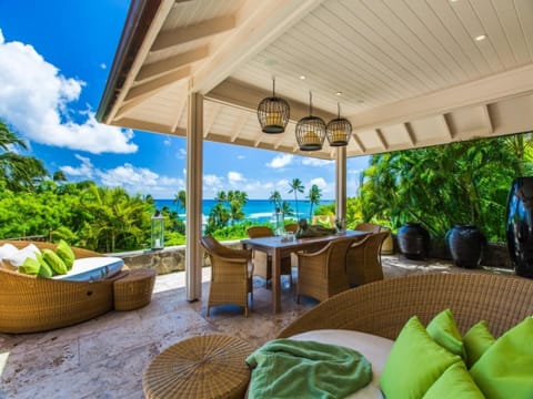 A covered lanai extends the living space outdoors, perfect for dining and lounging with coastal views.