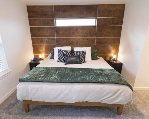 Master Bedroom.  King bed, side tables with charging stations, lamps, Alexa, sound machine, full length mirror, luggage rack and an extra blanket.