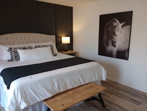 Chic king bedroom with bold accent wall, plush bedding, and modern art.