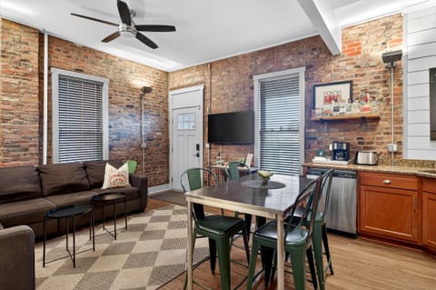 Relax on the brown sectional sofa or gather around the metal dining table for a game of cards. The large windows let in tons of natural light to brighten up the brick walls.