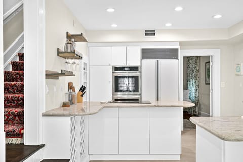 Your sleek modern kitchen awaits with pristine white cabinets, granite countertops, and premium stainless steel appliances for effortless meal preparation.