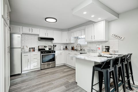 Bright kitchen with shaker cabinets, stainless appliances, and counters