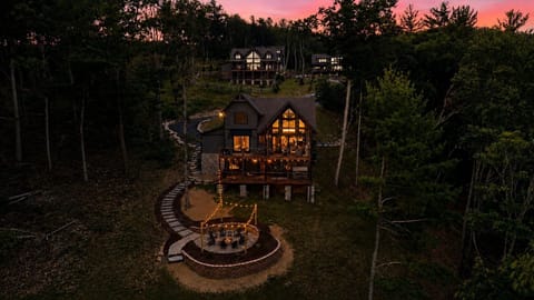 Sprawling mountain retreat with sweeping sunset views, a glowing deck for evening lounging, and a fire pit patio built for stargazing with family and friends.