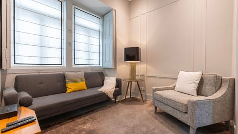 Stylish seating with modern textures, layered lighting, and large windows for a bright yet cozy space. #ElegantLiving #ComfortAndStyle
