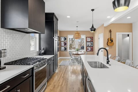 Spacious, fully-equipped kitchen for all your cooking needs. Modern appliances, natural lighting, and a large kitchen island with seating for 5. Dining area with additional seating for 4.