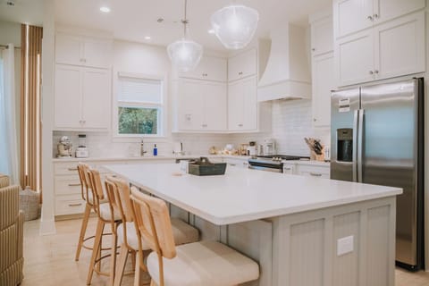 Fully equipped, chef-ready kitchen. The oversized kitchen island has 4 comfortable, rattan-backed, swivel counter stools at the island.