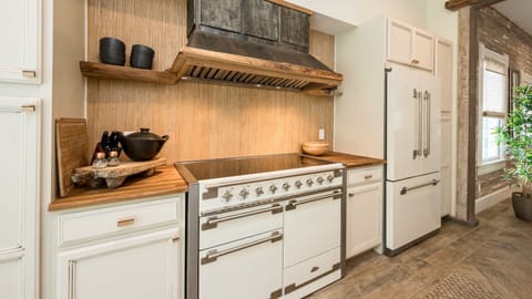 Your gourmet kitchen features warm wood countertops, professional-grade appliances, and rustic charm with exposed beams...