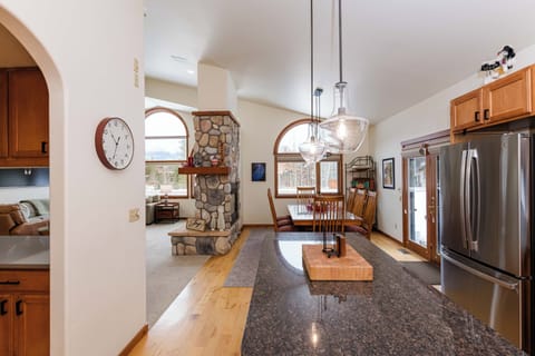 Your gourmet kitchen features granite countertops and stainless appliances, opening to a cozy living space with stone fireplace.