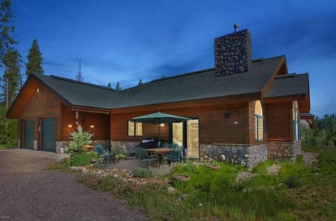 Rustic mountain lodge featuring natural stone and wood construction at evening twilight in the summer season
