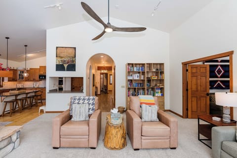 Sink into cozy leather chairs beneath soaring ceilings, where modern comfort meets southwestern charm in your expansive living space.