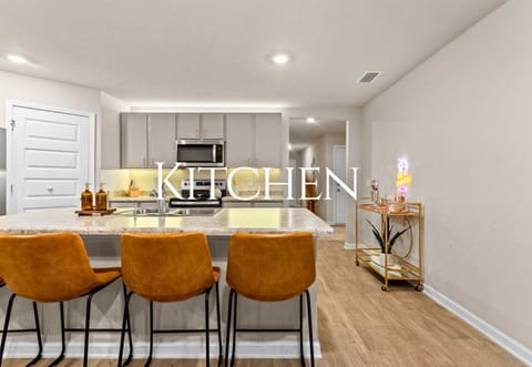 The kitchen is spacious and functional, with plenty of counter space and bar seating for casual meals or snacks.