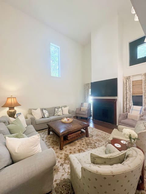 Spacious living room with high ceilings, plenty of ceiling, and large TV.